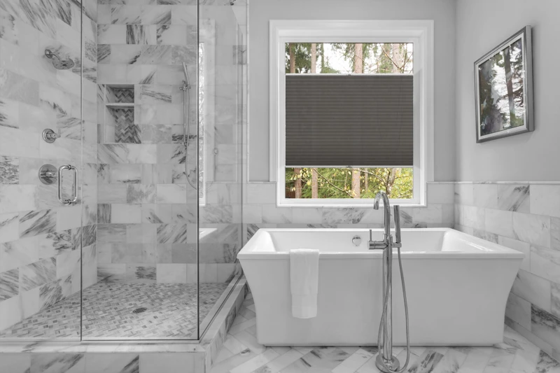 Bathroom with bathtub and shower in new luxury home with all gla