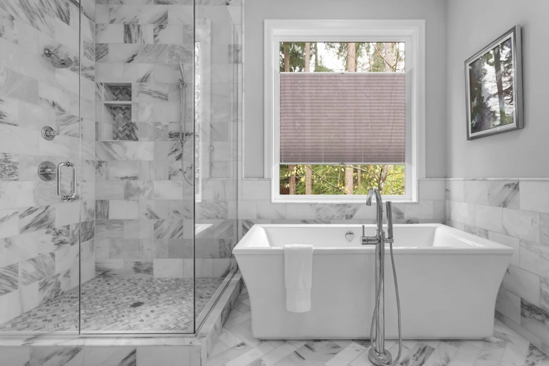 Bathroom with bathtub and shower in new luxury home with all gla